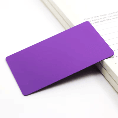 Produktfoto af et lilla blankt inkjet PVC-kort til specialprint placeret ved siden af en notesbog.