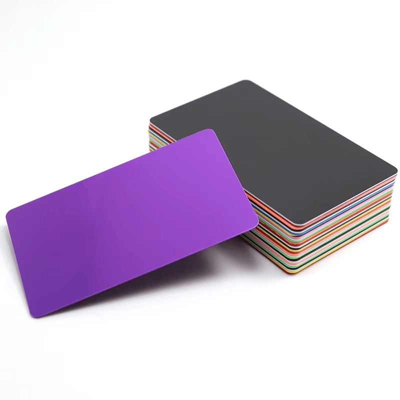 Blanke PVC-kort til kundetilpasset inkjettryk er stablet med et enkelt kort skråt foran for at vise glatte trykbare overflader.