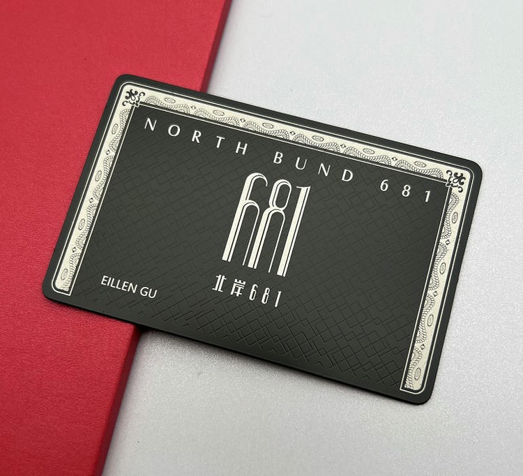 Dette metal visitkort viser en vintage-ramme med centreret branding og eksklusiv mørk tekstureret baggrund.