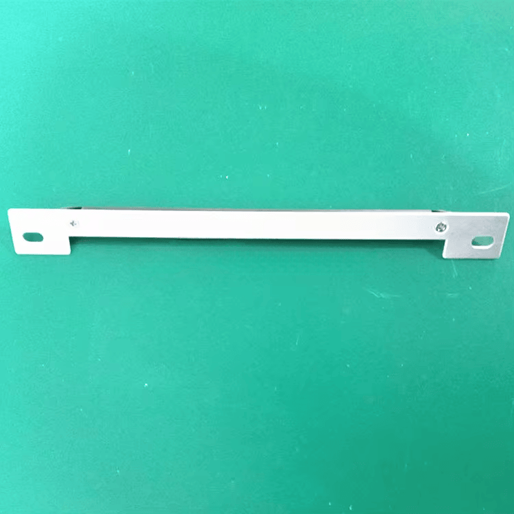 Enkelt metalbeslag vises på grøn overflade og illustrerer monteringsdelen til til metaloverflader RFID-tagget.