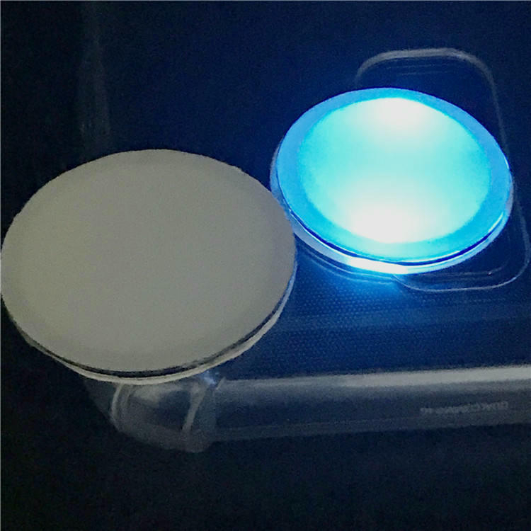 En smartphone berører en hvid NFC LED-etiket for at demonstrere funktionen med øjeblikkelig visuel lysfeedback